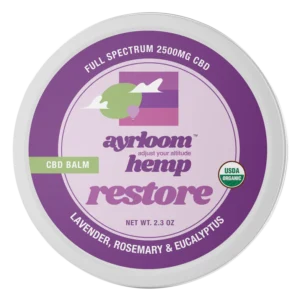 A small container of Ayrloom Restore Balm with calm lavender and green branding, highlighting lavender, rosemary, and eucalyptus.