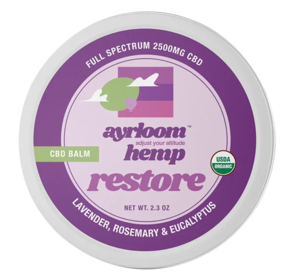 A small container of Ayrloom Restore Balm with calm lavender and green branding, highlighting lavender, rosemary, and eucalyptus.